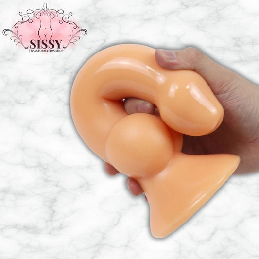 Gode XXL Avec Ventouse en silicone couleur chair tenu dans une main sur fond blanc marbré