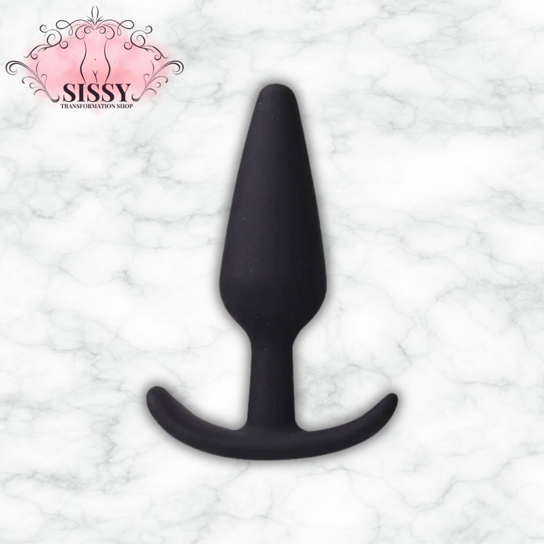 Plug anal en silicone noir de forme conique vendu par Sissy Transformation Shop sur fond marbre