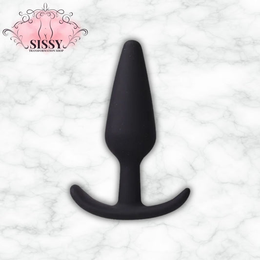 Plug anal en silicone noir de forme conique vendu par Sissy Transformation Shop sur fond marbre