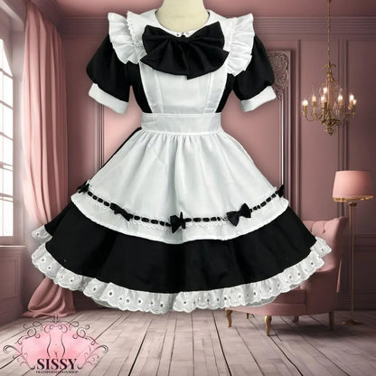 Robe sissy maid noire et blanche avec tablier et volants élégants sur mannequin intérieur