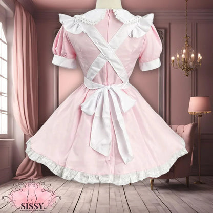 Robe sissy maid rose avec col dentelle et tablier blanc noué dans un intérieur élégant